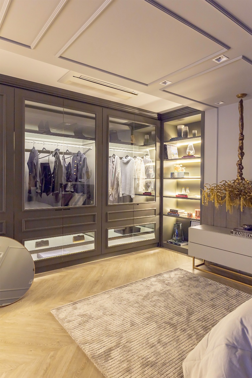 Closet com portas de vidro, iluminação interna e nichos expositores
